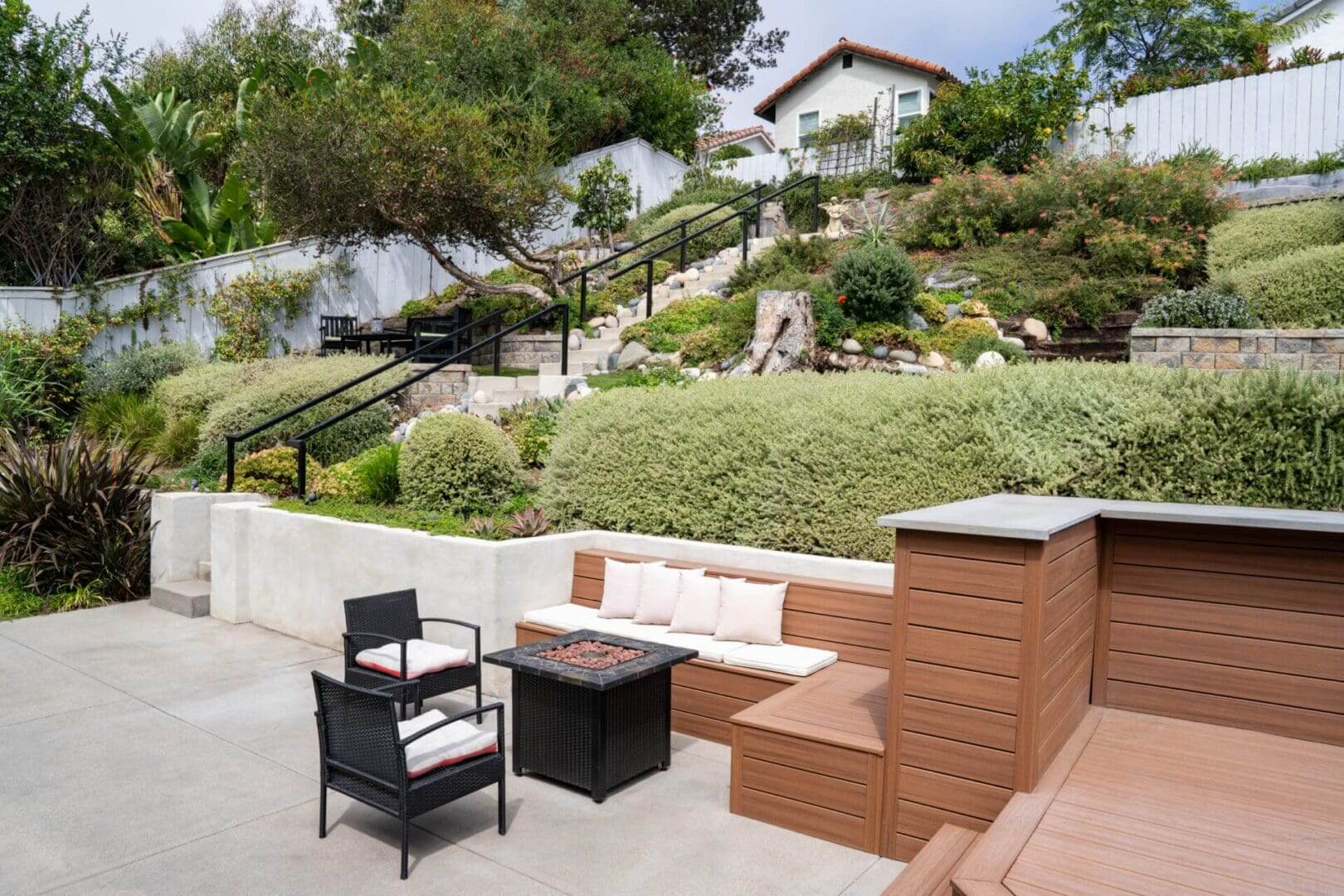 A patio with furniture and fire pit in the middle of a yard.