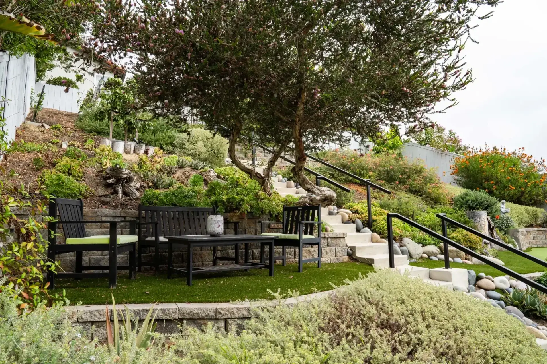 A garden with benches and stairs leading to the top of steps.