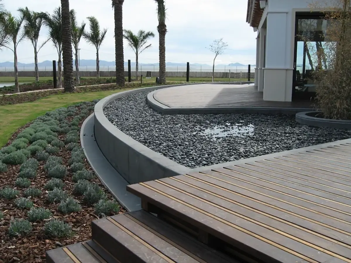 A deck with a view of the ocean and palm trees.