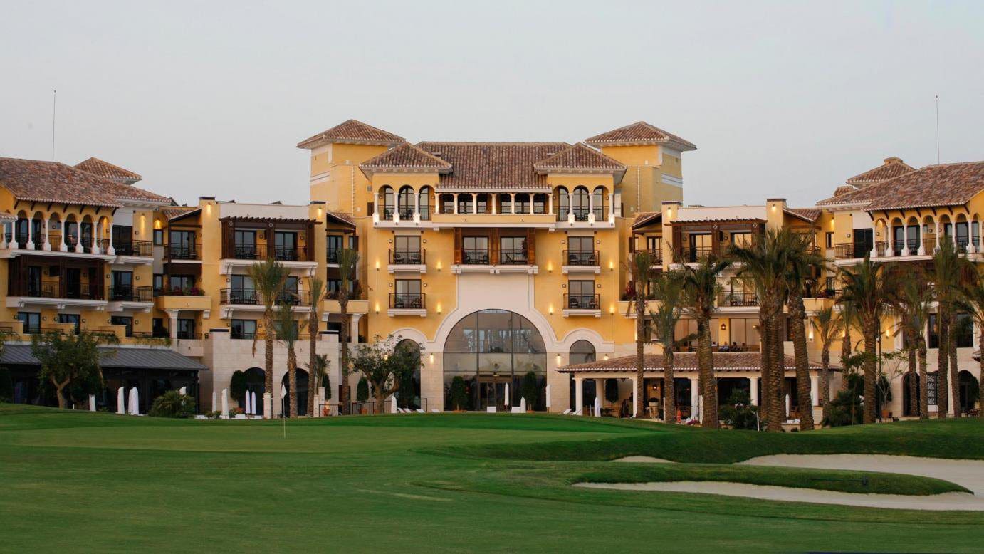 A large building with a green lawn in front of it.