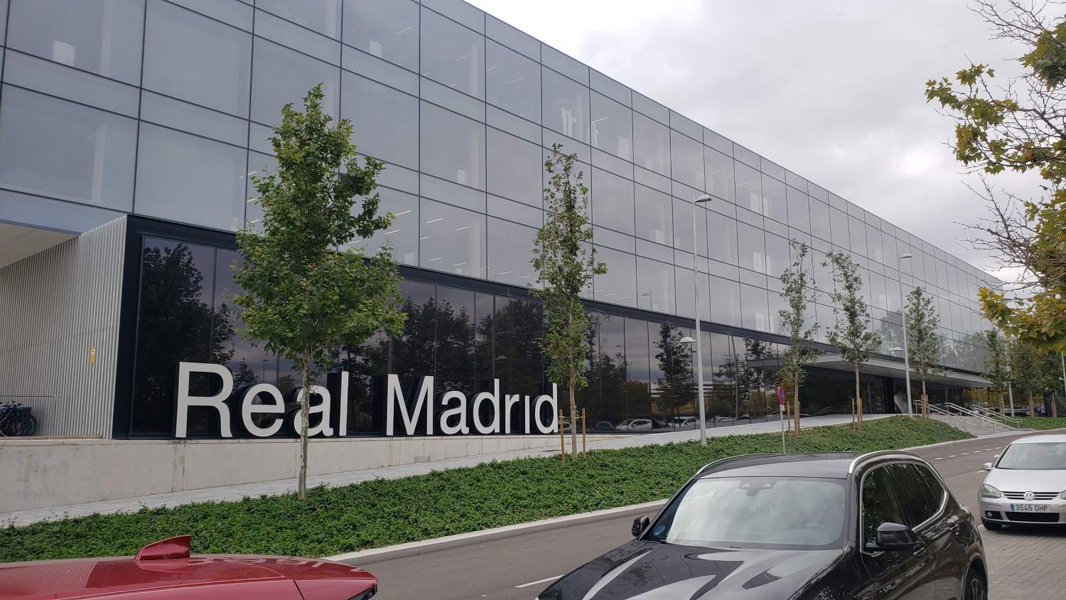 A car driving past a building with the word " real madrid ".