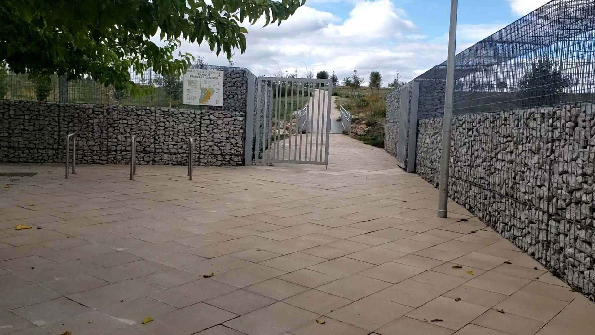 A walkway with metal gates and stone walls.