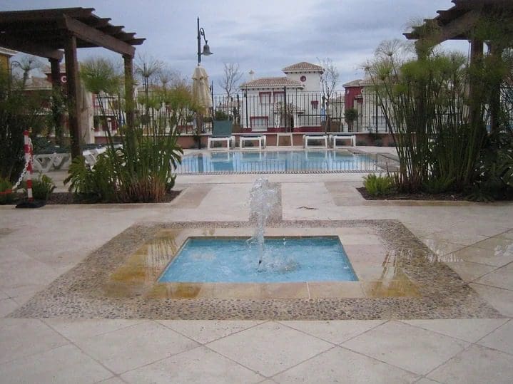 A pool with a fountain and a large deck