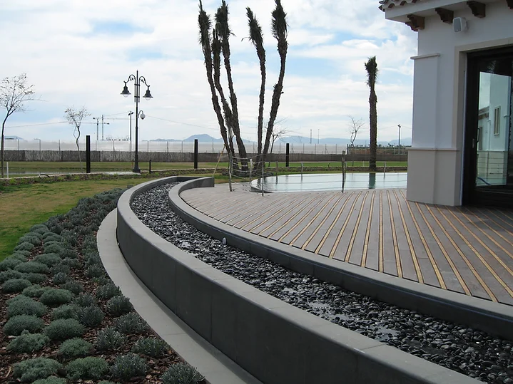 A walkway with plants and water in the background.