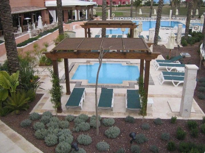 A view of an outdoor pool and patio area.