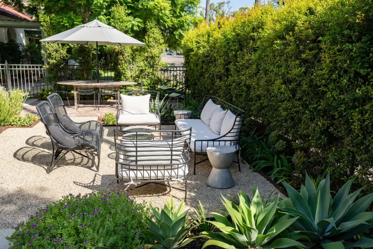 A patio with chairs, tables and umbrellas.