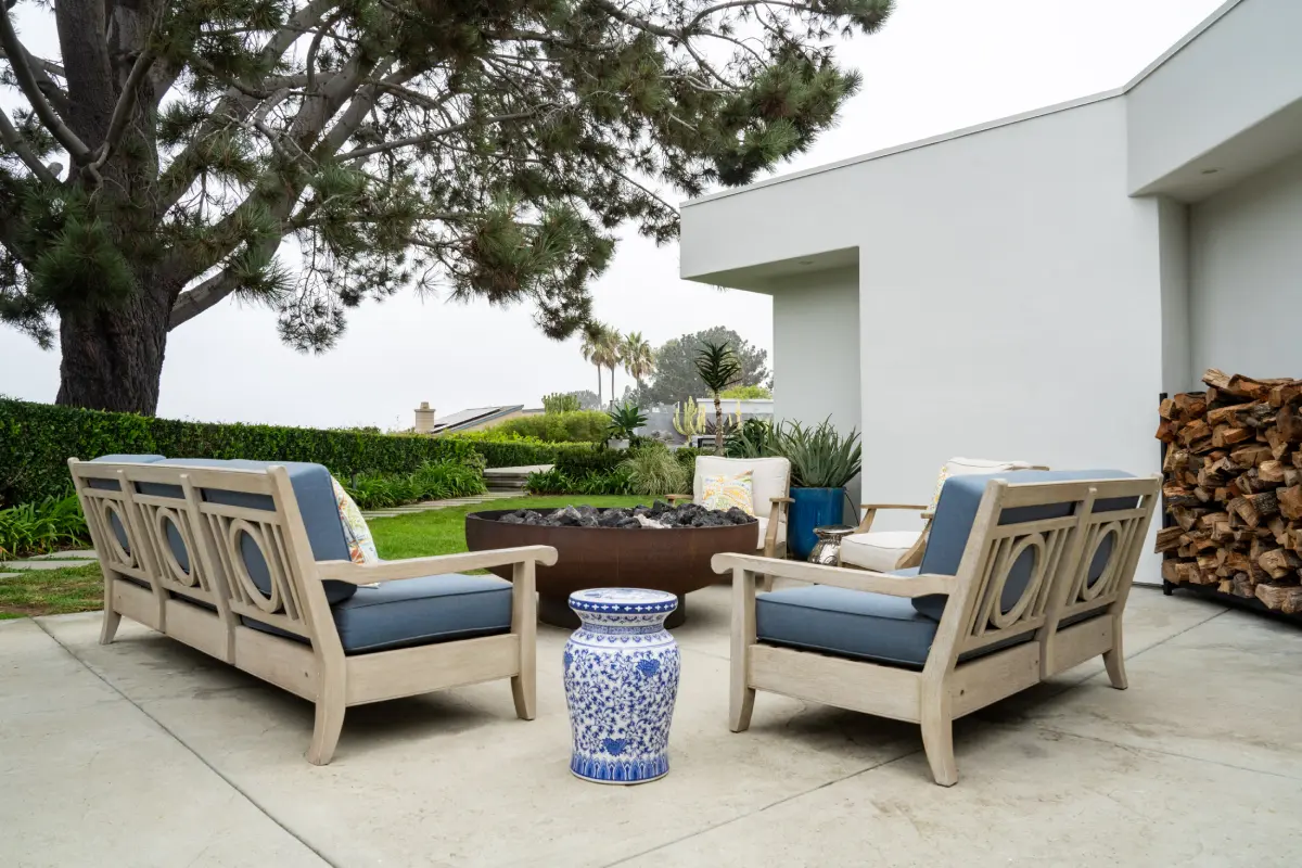 A patio with two chairs and a fire pit.