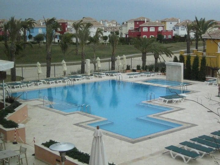 A large swimming pool with many chairs around it