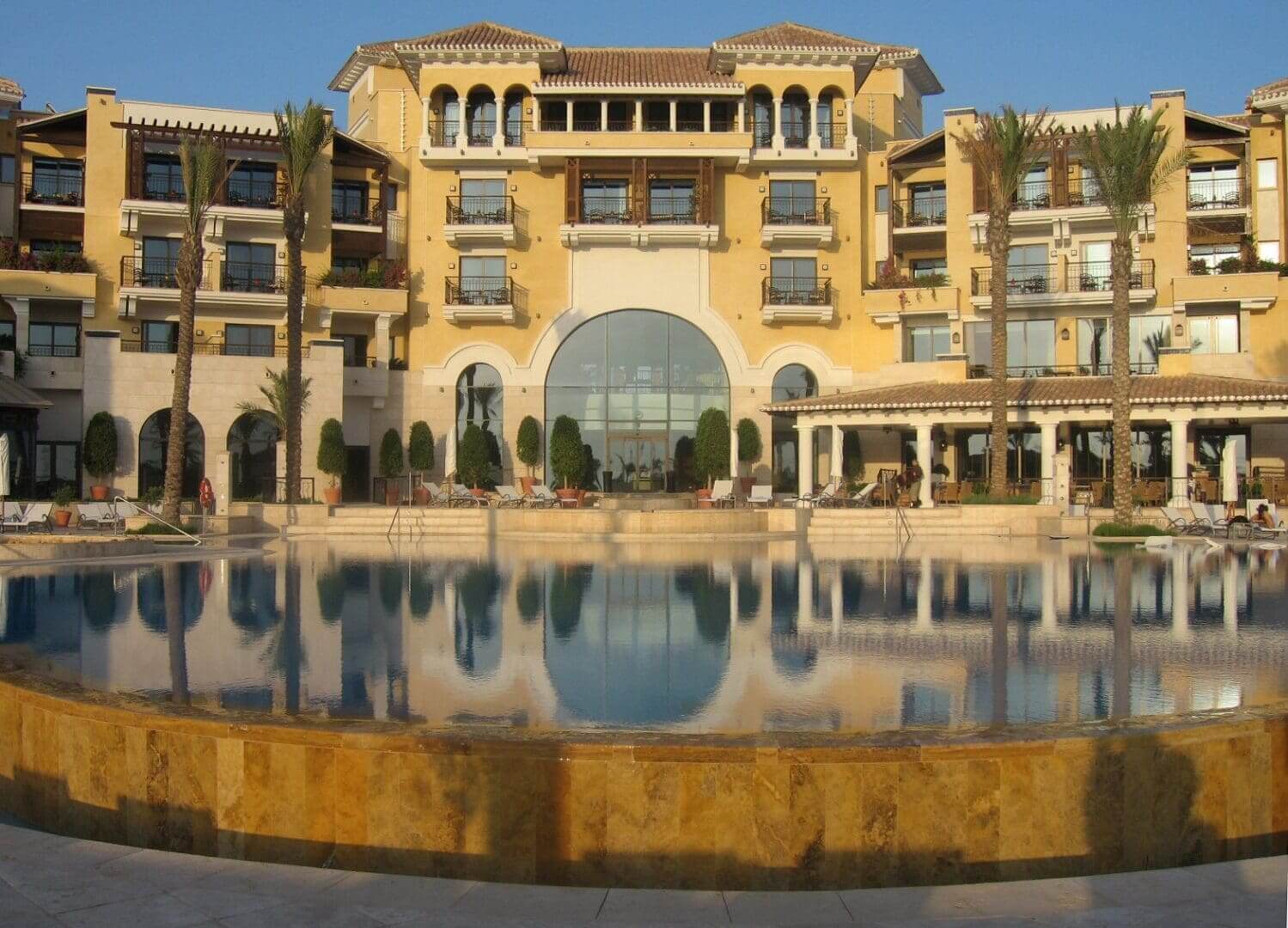 A large building with a pool in front of it