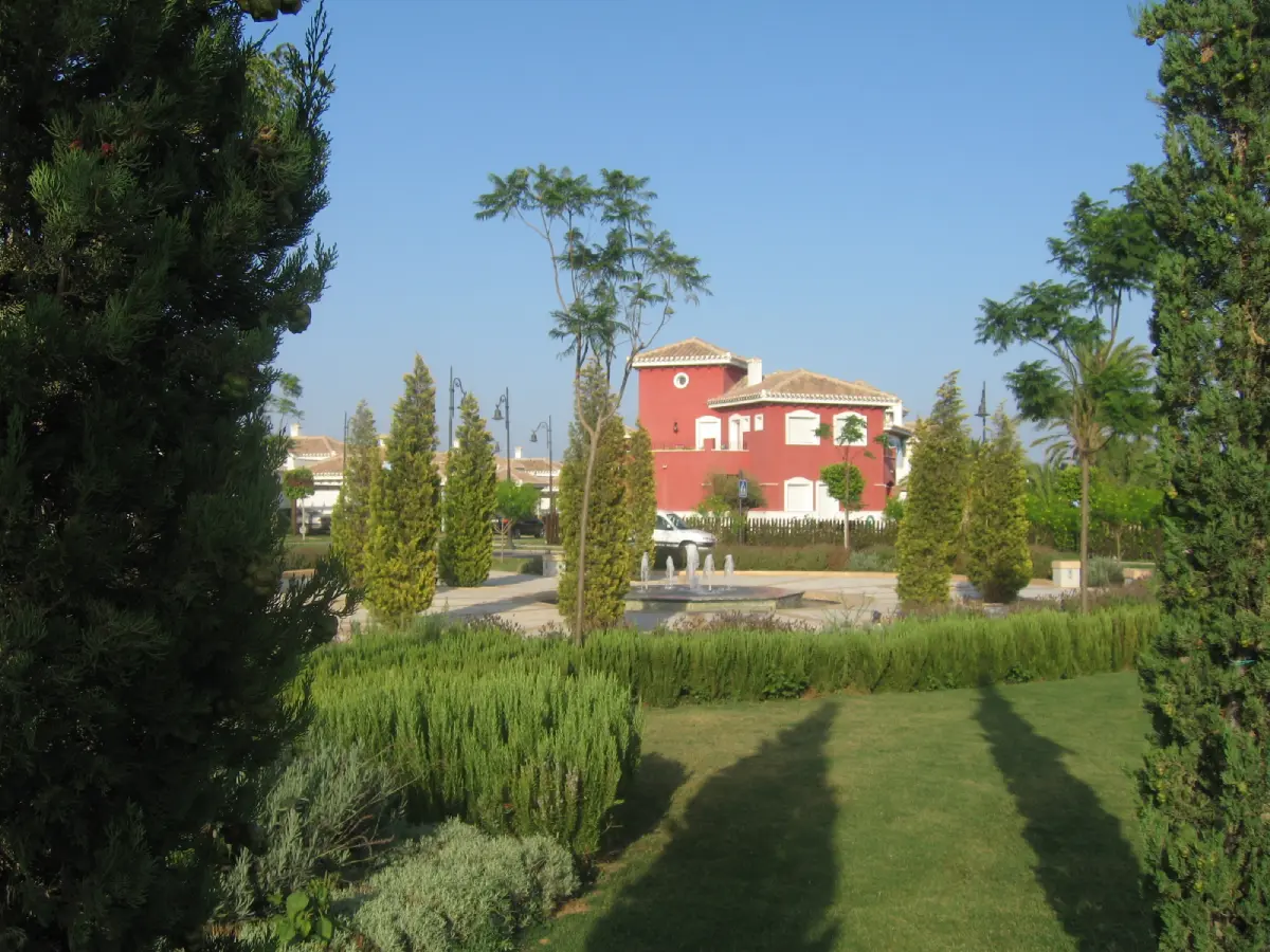 A red house with trees in the foreground