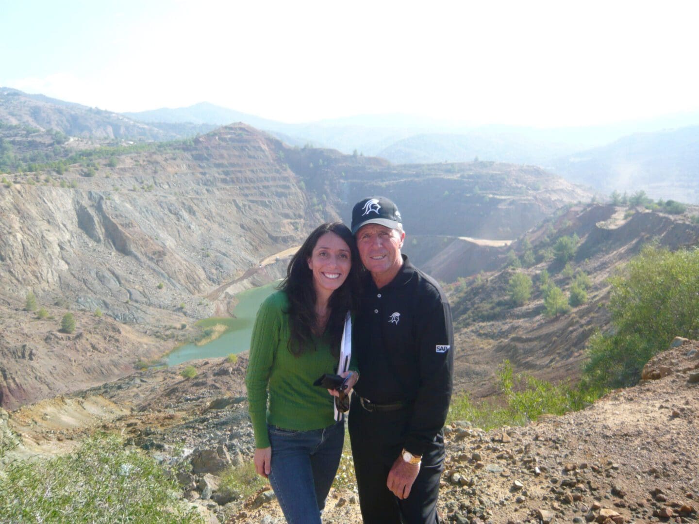 A man and woman standing on top of a mountain.