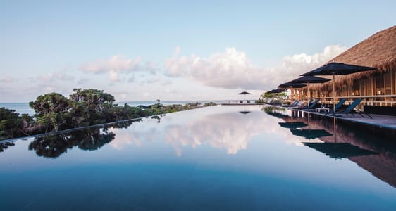 Infinity pool overlooking ocean and sky.