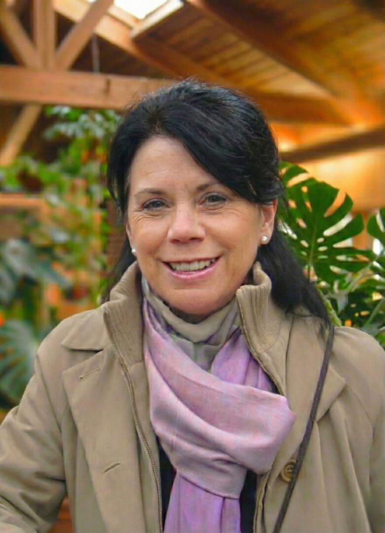 Woman smiling in indoor garden setting.
