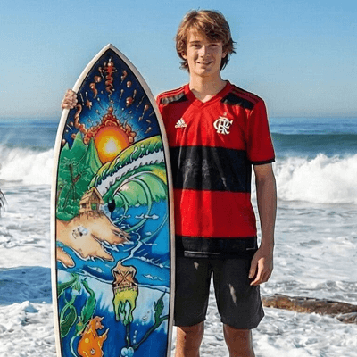 Person holding colorful surfboard on beach.