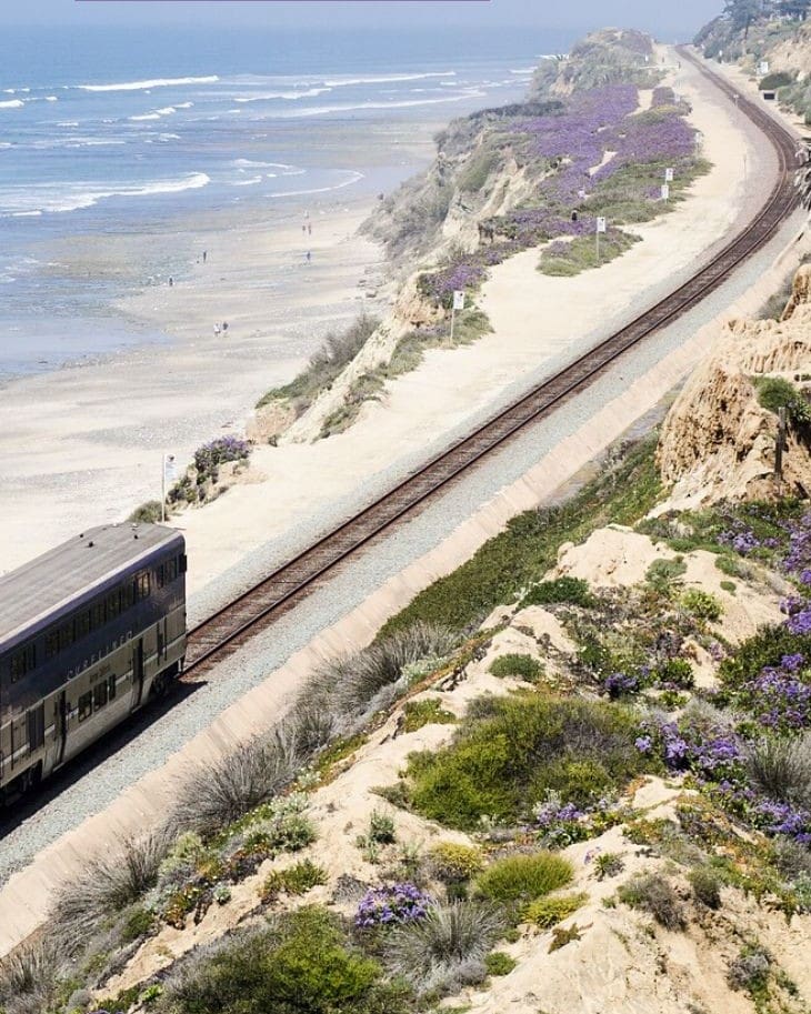 Train traveling along scenic coastal railway line.