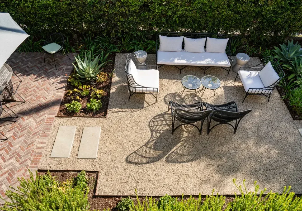 A patio with furniture and plants in the middle of it.