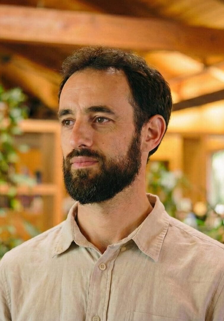 Man in wooden interior with plants.