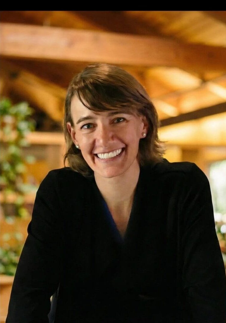 Smiling person in a wooden interior setting.